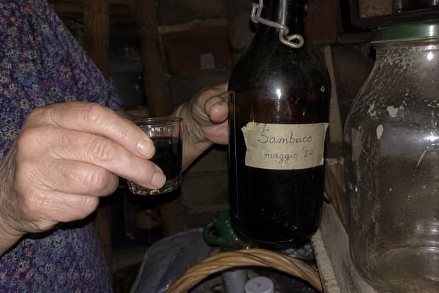 La bottiglia di sciroppo di sambuco con l'etichetta scritta a mano
